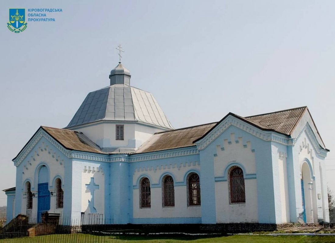 Стара церква з біло-блакитними стінами та металевим дахом. Будівля має купол, увінчаний хрестом. Вікна аркової форми і розташовані симетрично. На фасаді будівлі напроти входу видно великий хрест, виконаний у формі тіні. На верхньому лівому куті зображено логотип та напис "Кіровоградська обласна прокуратура". Перед будівлею знаходиться зелена трав'яна ділянка.